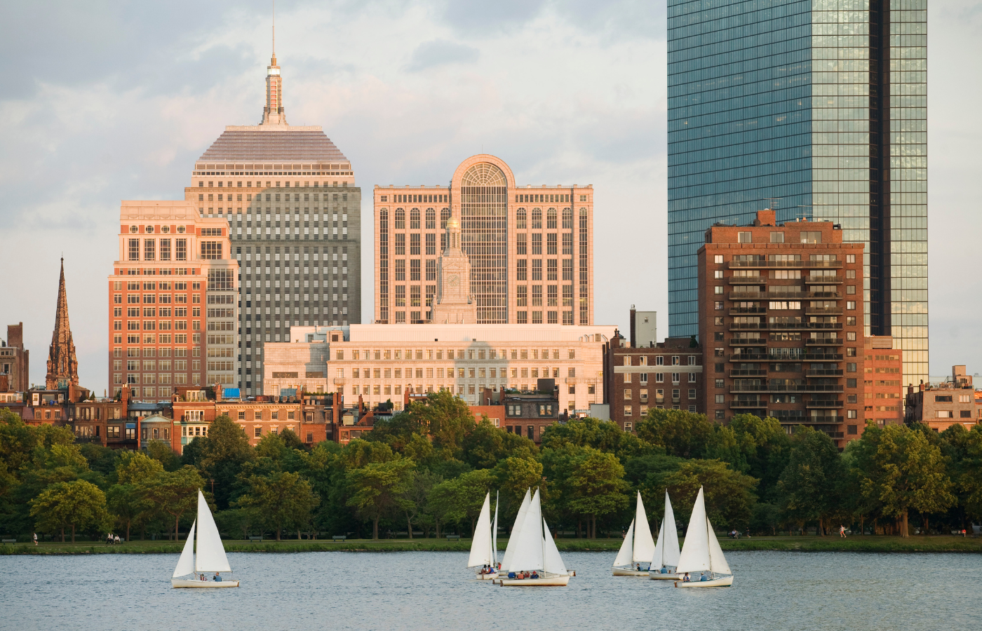 Sailboats sailing underneath the Boston, Massachusetts, skyline.